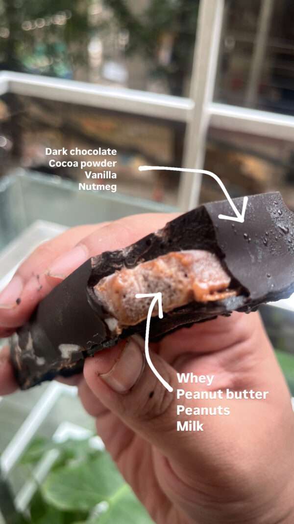 Ismail Sayeed holding a Sarco Bar with a bite taken out of it