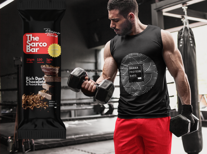 Young man working out in a gym with bicup curls while wearing dhaka protein bars tshirt next to a sarco bar